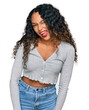 © Krakenimages.com - Young hispanic woman with curly hair wearing casual clothes winking looking at the camera with sexy expression, cheerful and happy face.