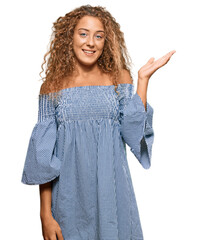 Sticker - Beautiful caucasian teenager girl wearing summer dress smiling cheerful presenting and pointing with palm of hand looking at the camera.