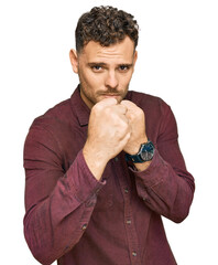 Sticker - Young hispanic man wearing casual clothes ready to fight with fist defense gesture, angry and upset face, afraid of problem