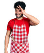 © Krakenimages.com - Young arab man with beard wearing cook apron doing ok gesture with hand smiling, eye looking through fingers with happy face.