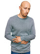 © Krakenimages.com - Bald man with beard wearing casual clothes with hand on stomach because indigestion, painful illness feeling unwell. ache concept.