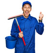 © Krakenimages.com - Bald man with beard wearing glass cleaner uniform and squeegee screaming proud, celebrating victory and success very excited with raised arms