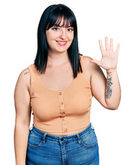 Wall Mural - Young hispanic plus size woman wearing casual clothes showing and pointing up with fingers number five while smiling confident and happy.