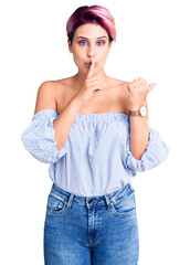 Wall Mural - Young beautiful woman with pink hair wearing casual clothes asking to be quiet with finger on lips pointing with hand to the side. silence and secret concept.