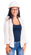 © Krakenimages.com - Young beautiful latin girl wearing architect hardhat and glasses winking looking at the camera with sexy expression, cheerful and happy face.