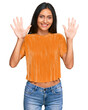 © Krakenimages.com - Young brunette arab woman wearing casual clothes showing and pointing up with fingers number ten while smiling confident and happy.