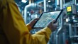 © Youttakone - engineer or factory worker using tablet computer for finding how to use machine control panel in factory
