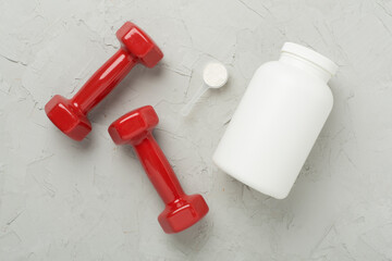 Wall Mural - Jars with protein powder and dumbbells on concrete background, top view. Sports nutrition concept