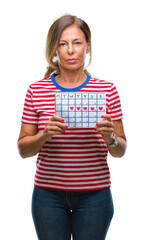 Wall Mural - middle age senior hispanic woman holding menstruation calendar over isolated background with a confi