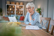 © Miljan Živković - Senior caucasian woman use laptop computer at home for work