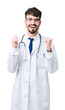 © Krakenimages.com - Young doctor man wearing hospital coat over isolated background celebrating surprised and amazed for success with arms raised and open eyes. Winner concept.