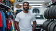 © Lens Legacy - A man wearing a white shirt stands in an auto shop, flanked by tires and jerseys, conveying a sense of confidence and industriousness in an automotive environment.