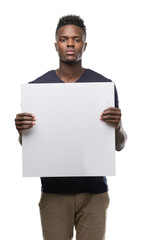 Young african american man holding a banner with a confident expression on smart face thinking serious