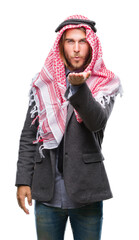 Sticker - Young handsome arabian man with long hair wearing keffiyeh over isolated background looking at the camera blowing a kiss with hand on air being lovely and sexy. Love expression.