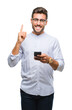 © Krakenimages.com - Young handsome man texting using smartphone over isolated background surprised with an idea or question pointing finger with happy face, number one