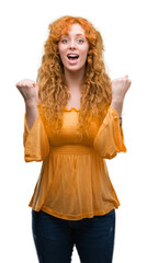 Sticker - Young redhead woman celebrating surprised and amazed for success with arms raised and open eyes. Winner concept.