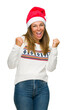 © Krakenimages.com - Middle age adult woman wearing winter sweater and chrismat hat over isolated background very happy and excited doing winner gesture with arms raised, smiling and screaming for success