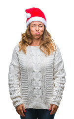 Sticker - Middle age senior hispanic woman wearing christmas hat over isolated background puffing cheeks with funny face. Mouth inflated with air, crazy expression.