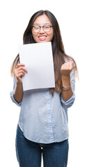 Canvas Print - Young asian woman holding blank paper over isolated background screaming proud and celebrating victory and success very excited, cheering emotion