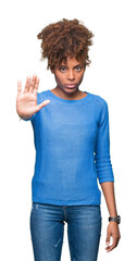 Wall Mural - Beautiful young african american woman over isolated background doing stop sing with palm of the hand. Warning expression with negative and serious gesture on the face.