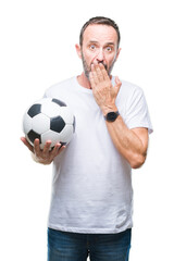 Wall Mural - Middle age hoary senior man holding soccer football ball over isolated background cover mouth with hand shocked with shame for mistake, expression of fear, scared in silence, secret concept