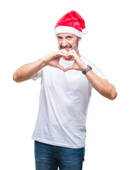 Poster - Middle age hoary senior man wearing christmas hat over isolated background smiling in love showing heart symbol and shape with hands. Romantic concept.