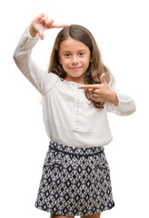 Wall Mural - Brunette hispanic girl smiling making frame with hands and fingers with happy face. Creativity and photography concept.