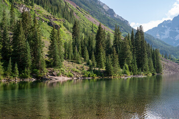 Wall Mural - Maroon Bells reflected in Maroon Lake on sunny summer afternoon under dramatic summer cloudscape.