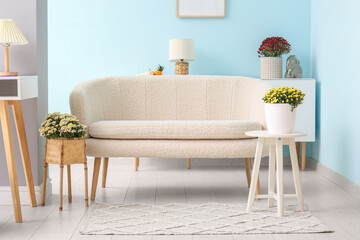 Wall Mural - Interior of modern living room with white sofa and beautiful chrysanthemum flowers