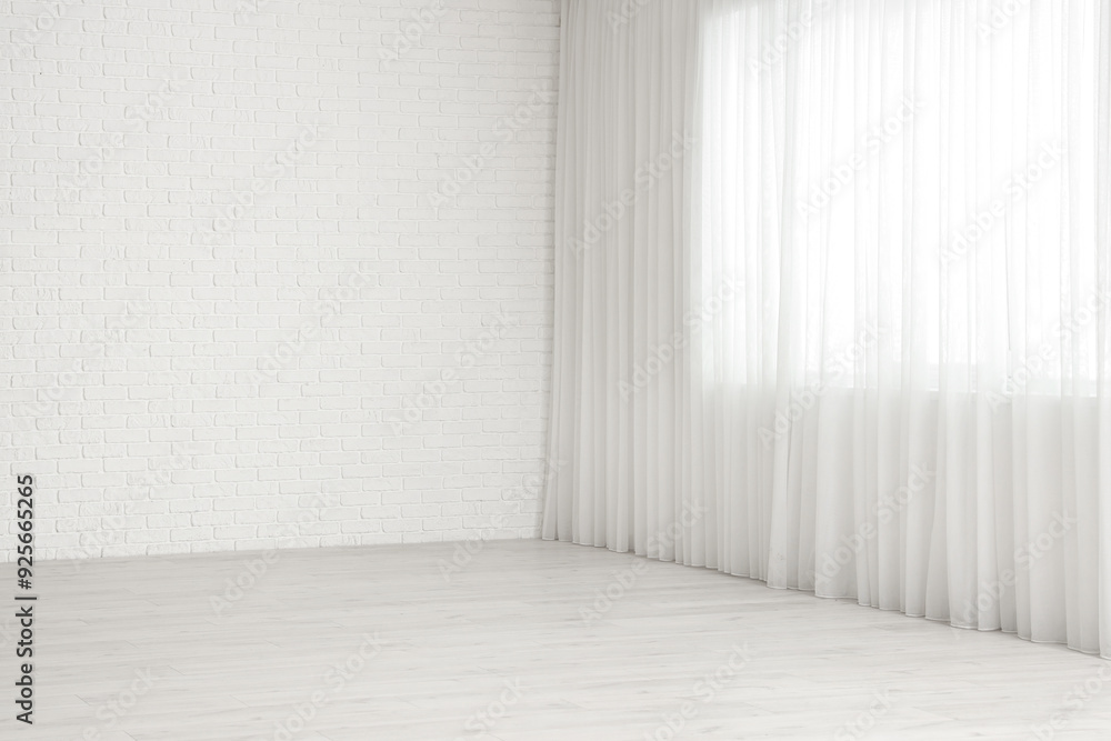 View of empty room with laminate floor and window curtain