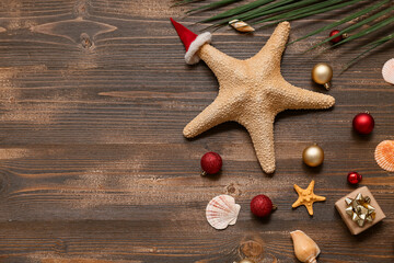 Wall Mural - Starfish and palm branch with Christmas decor on wooden background. Top view