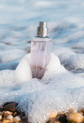 Wall Mural - Bottle of aromatic perfume on sea shore, closeup