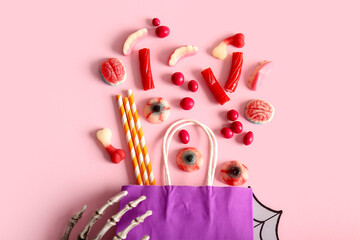 Wall Mural - Composition with shopping bag, treats and decorations for Halloween on pink background, closeup