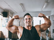 © peopleimages.com - Fitness, gym and man flexing for muscle portrait, wellness or exercise at club. Warm up, training and bodybuilder person workout for flexibility, sports or physical activity of athlete with smile