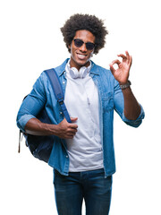 Wall Mural - Afro american man wearing headphones and backpack over isolated background doing ok sign with fingers, excellent symbol