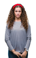 Wall Mural - Beautiful brunette curly hair young girl wearing stripes sweater over isolated background with serious expression on face. Simple and natural looking at the camera.