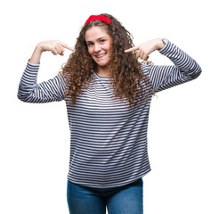 Wall Mural - Beautiful brunette curly hair young girl wearing stripes sweater over isolated background looking confident with smile on face, pointing oneself with fingers proud and happy.