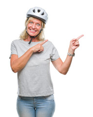 Poster - Middle age caucasian cyclist woman wearing safety helmet over isolated background smiling and looking at the camera pointing with two hands and fingers to the side.