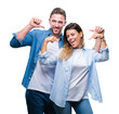 © Krakenimages.com - Young couple in love over isolated background looking confident with smile on face, pointing oneself with fingers proud and happy.