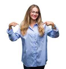 Poster - Young beautiful blonde business woman wearing glasses over isolated background looking confident with smile on face, pointing oneself with fingers proud and happy.