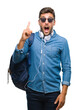 © Krakenimages.com - Young handsome tourist man wearing headphones and backpack over isolated background pointing finger up with successful idea. Exited and happy. Number one.
