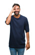 © Krakenimages.com - Adult hispanic man over isolated background doing ok gesture with hand smiling, eye looking through fingers with happy face.