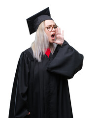 Canvas Print - Young blonde woman wearing graduate uniform over isolated background shouting and screaming loud to side with hand on mouth. Communication concept.