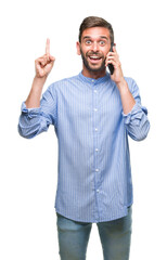 Canvas Print - Young handsome man speaking on the phone over isolated background surprised with an idea or question pointing finger with happy face, number one