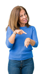 Wall Mural - Middle age beautiful woman wearing winter sweater over isolated background In hurry pointing to watch time, impatience, upset and angry for deadline delay