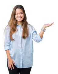 Canvas Print - Young beautiful brunette business woman over isolated background smiling cheerful presenting and pointing with palm of hand looking at the camera.