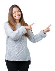 Canvas Print - Young beautiful brunette woman wearing sweater over isolated background smiling and looking at the camera pointing with two hands and fingers to the side.