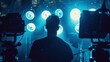 © buraratn - Silhouette of a crew member adjusting studio lights, showcasing the behind-the-scenes action in video production.