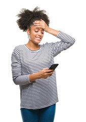 Canvas Print - Young afro american woman texting using smartphone over isolated background stressed with hand on head, shocked with shame and surprise face, angry and frustrated. Fear and upset for mistake.