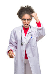 Wall Mural - Young afro american doctor woman over isolated background angry and mad raising fist frustrated and furious while shouting with anger. Rage and aggressive concept.